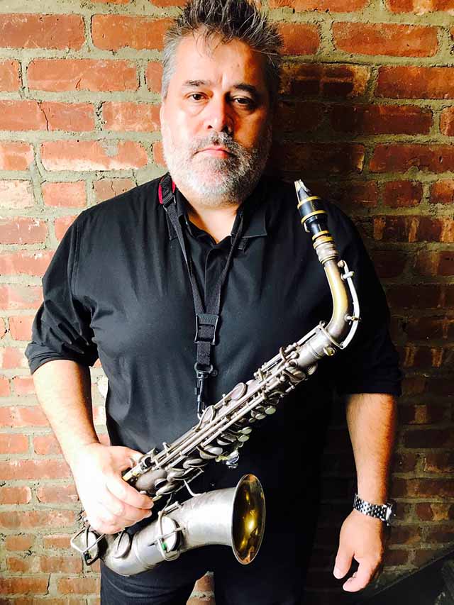 Oscar Noriega holding saxophone